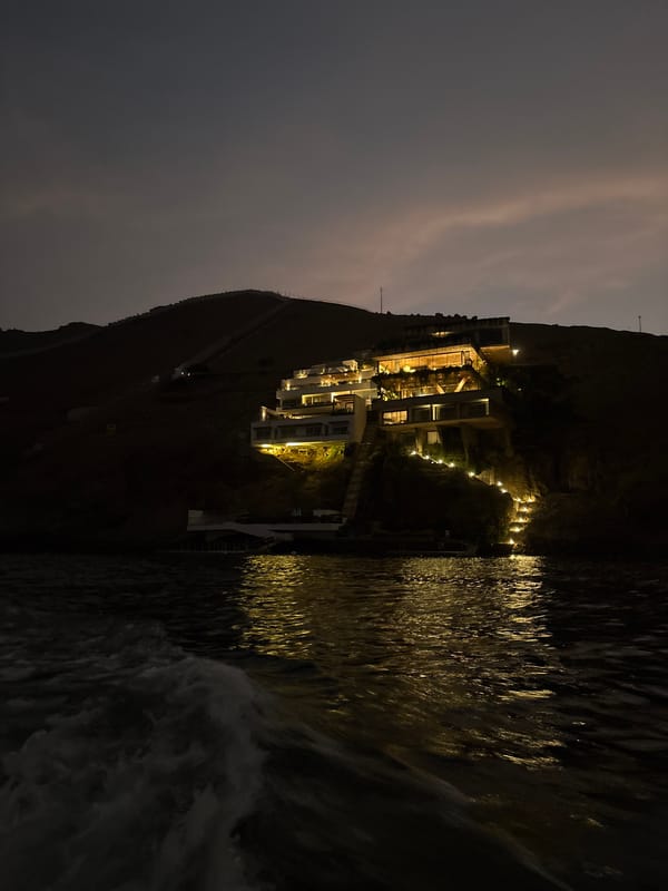 Illuminated hillside buildings captured at night in Ancón, Peru