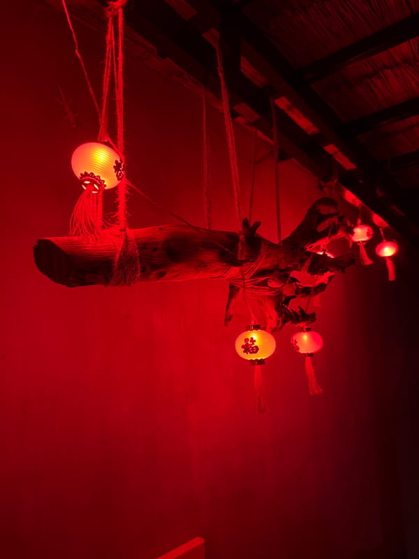 Red-lit wooden post installation captured in Nha Trang