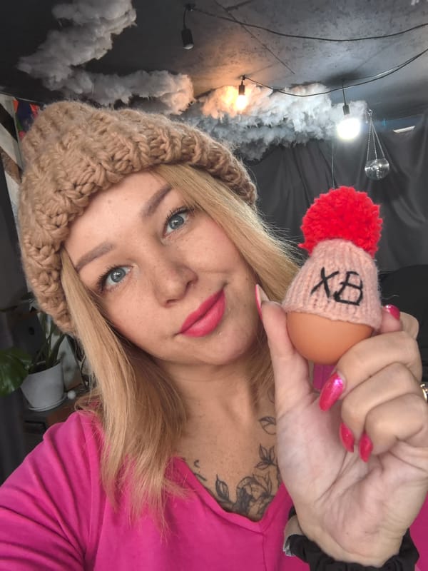 Woman holds decorated egg with knitted hat in Noviy, Russia