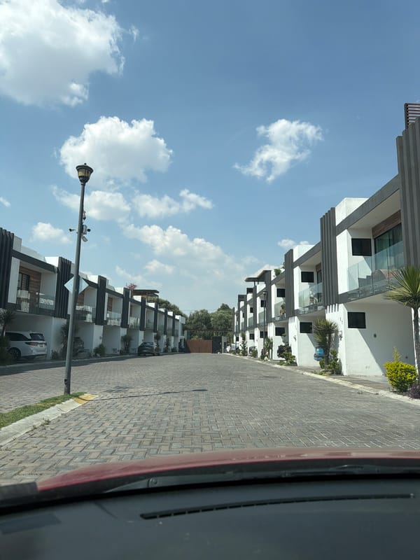 Vehicle occupant observes paved residential street in Cholula, Mexico