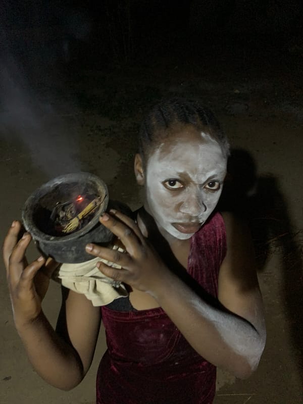 Woman holds smoking pot with white face paint in Nigeria