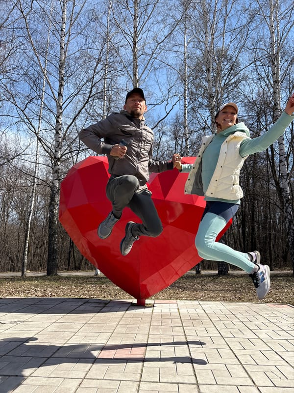 Couple poses at red heart sculpture in Ulyanovsk park
