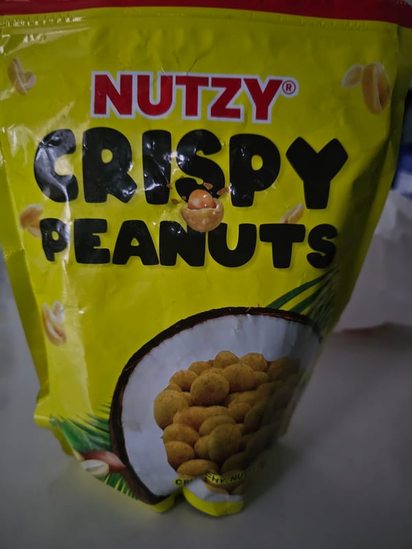 Yellow peanut snack bag photographed against grey background
