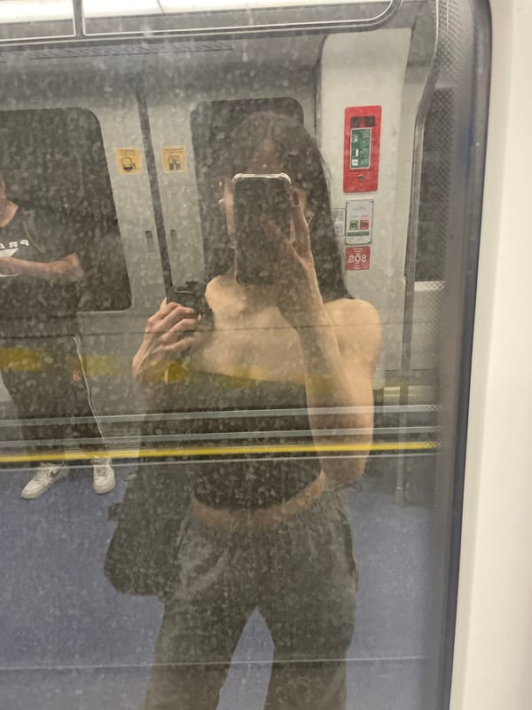 Train passenger reflection captured in Milan transit window
