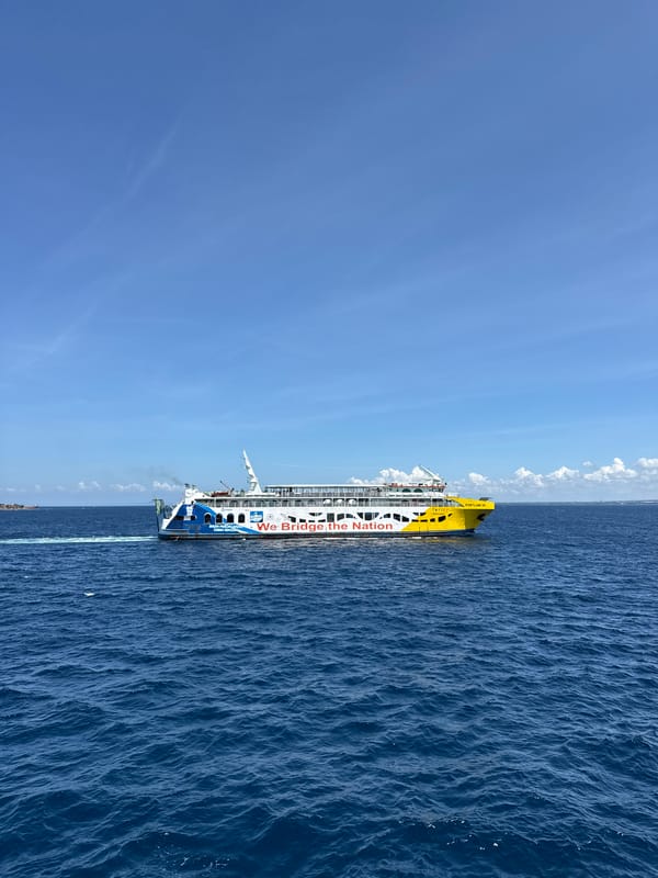Ferry sails near Melaya coast under clear skies