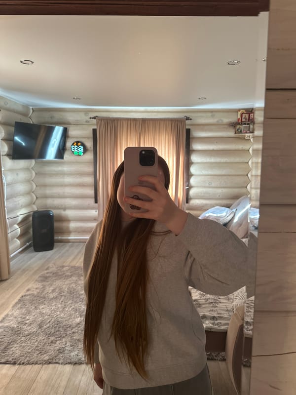 Woman documents selfie session with cat in Russian log cabin