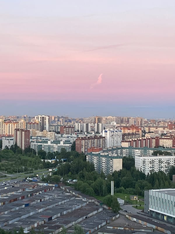 Aerial view captures city at dusk with colorful sky