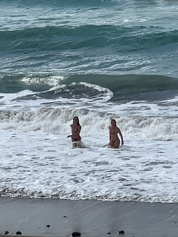 Typical beach day unfolds in Las Palmas with surfers, swimmers