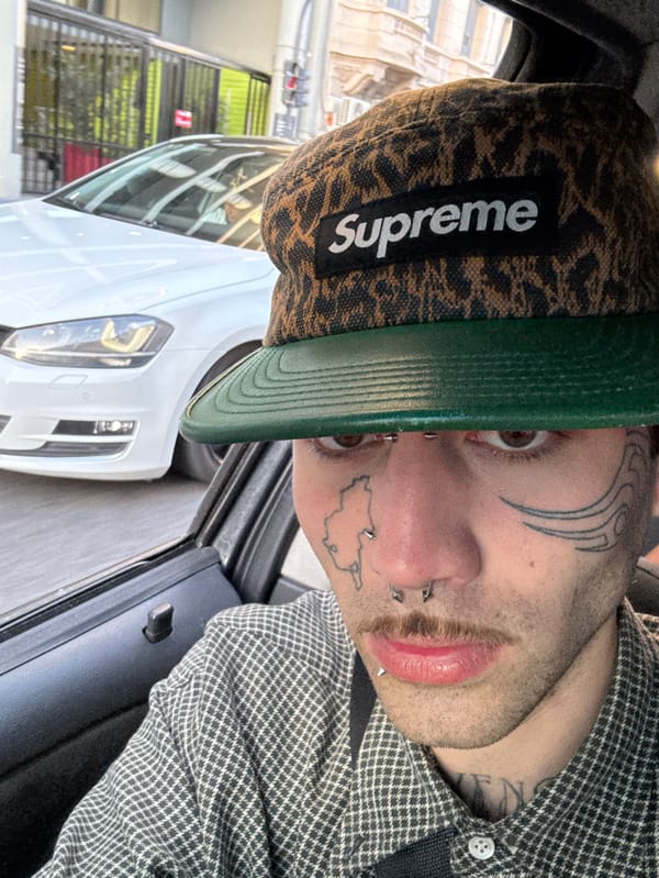 Tattooed individual spotted wearing distinctive Supreme hat in Buenos Aires