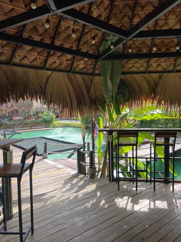 Thatched resort by a turquoise pond in southern Thailand