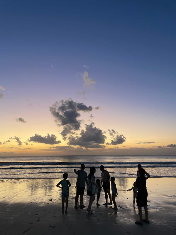 Kuta Selatan beach at dusk: surfers, soccer, and sunset silhouettes