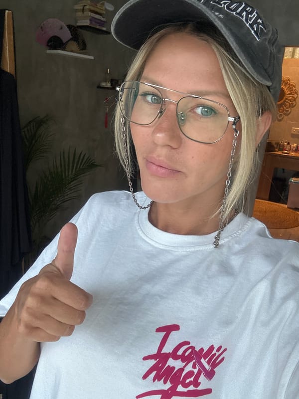 Woman makes mixed thumbs gestures at desk in North Kuta
