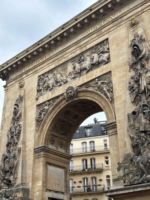 Tourist photographs historic Arc de Triomphe du Carrousel in Paris