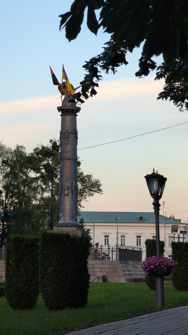 Cylindrical monument amid green bushes in Novyi Merchyk