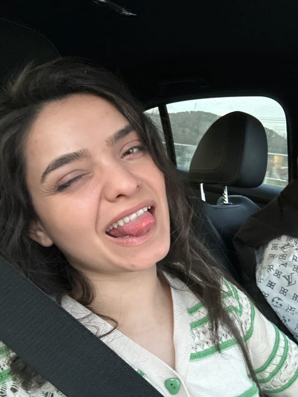 Woman makes playful faces while seated in car, Bulgaria