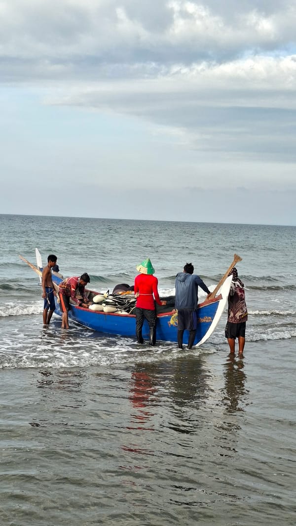 Fishermen and beachgoers share a cloudy morning in Lhokseumawe