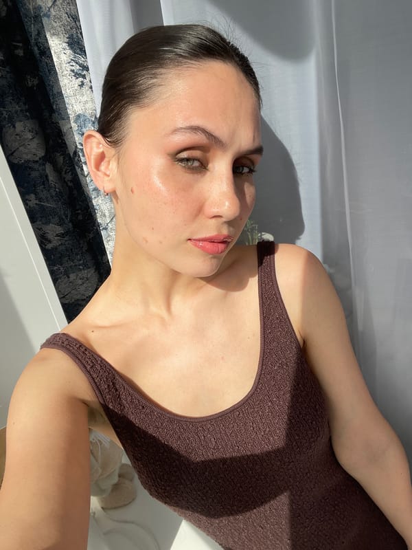 Woman photographs herself with tulips indoors in Izhevsk