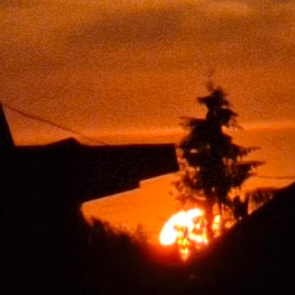 Fire and crane silhouetted against orange sky in Russian construction zone