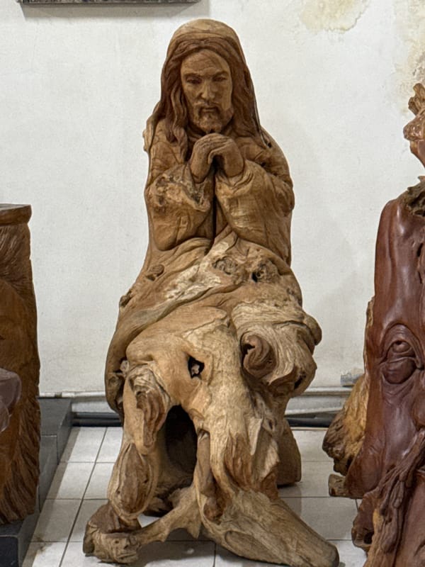 Visitor documents wooden art collection at Denpasar gallery