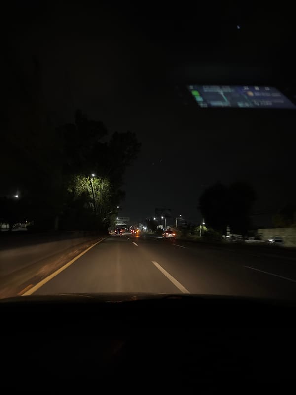 Nighttime drive captured on illuminated Puebla city streets