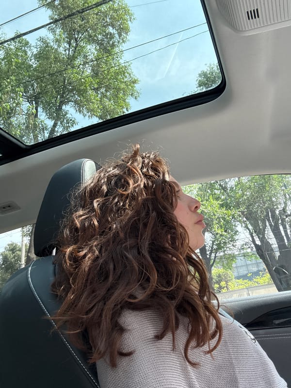 Woman rests in passenger seat during evening drive in Mexico City