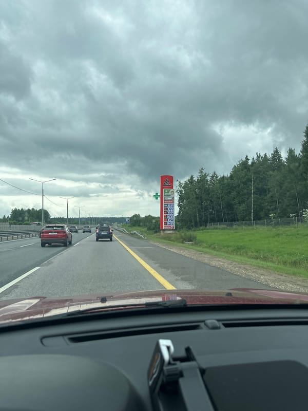 Highway drive under heavy clouds, roadside infrastructure in view