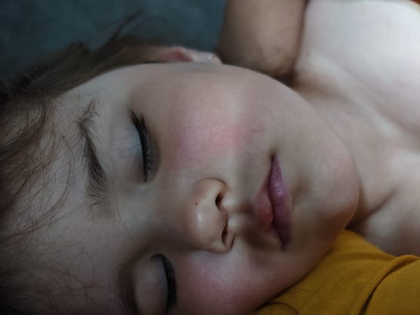 Child sleeps peacefully on yellow fabric in Chaikovsky