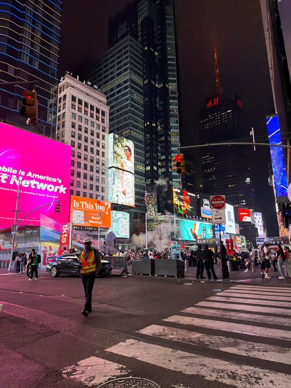 Times Square at 4am, billboards blazing through the fog