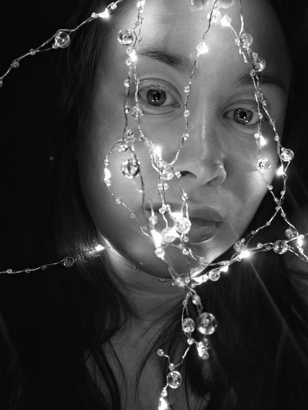 Face behind fairy lights, night outside, rural road