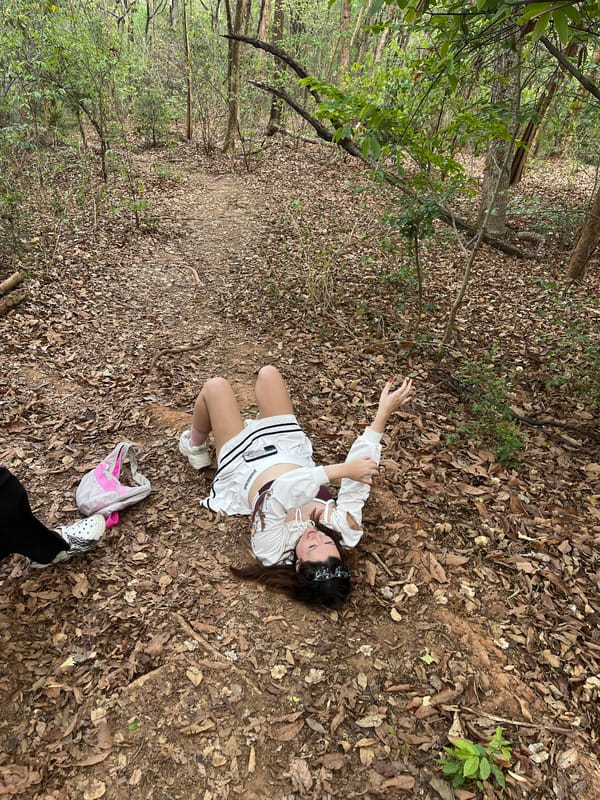 Woman in white lies on wooded path in Chiang Mai