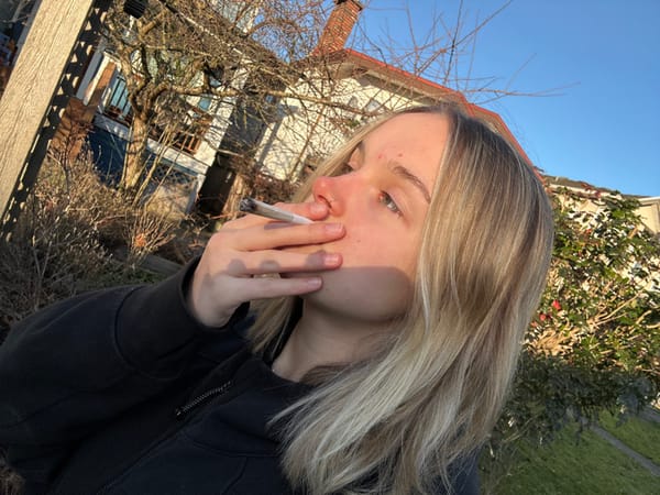 Young adult smokes on sunny Vancouver residential street