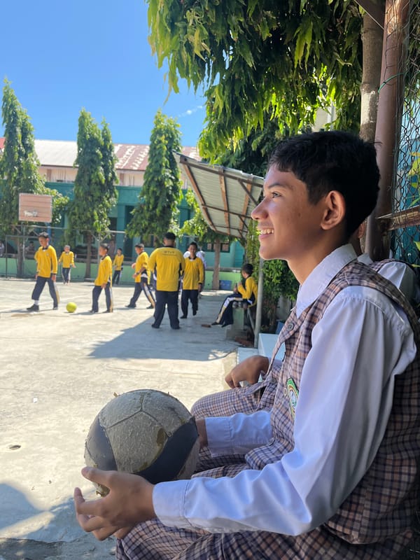 Kids with soccer balls on a school court in Lhokseumawe