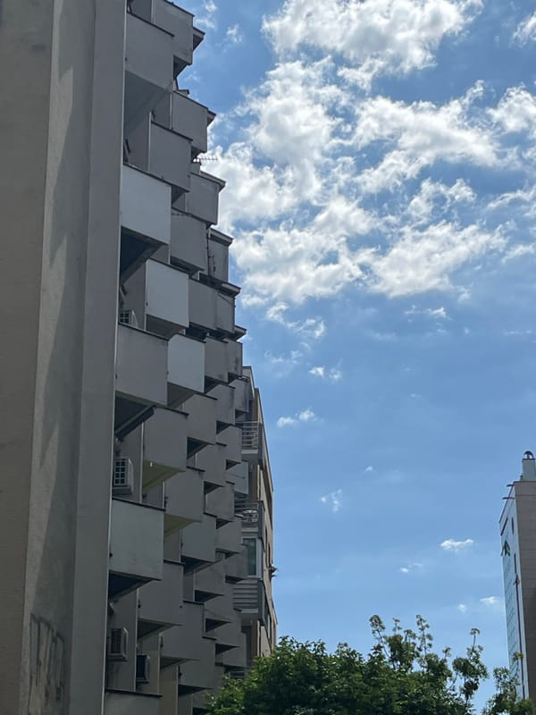 Woman photographed near pyramid-roofed building in Novi Sad