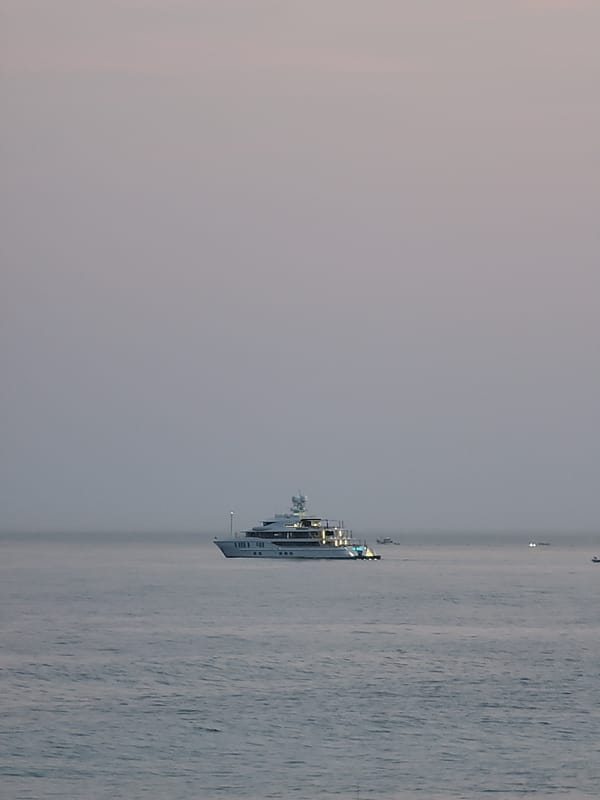 Sunset downtime on Quarteira Beach, yacht on the horizon.