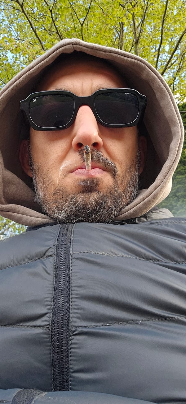 Man smoking outdoors in Norwich park setting