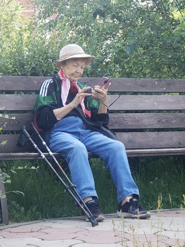 Scrolling through a phone on a park bench
