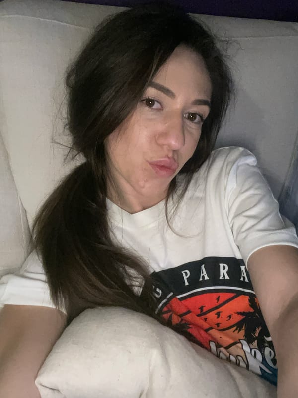 Woman rests on sofa wearing Paradise shirt in Sofia
