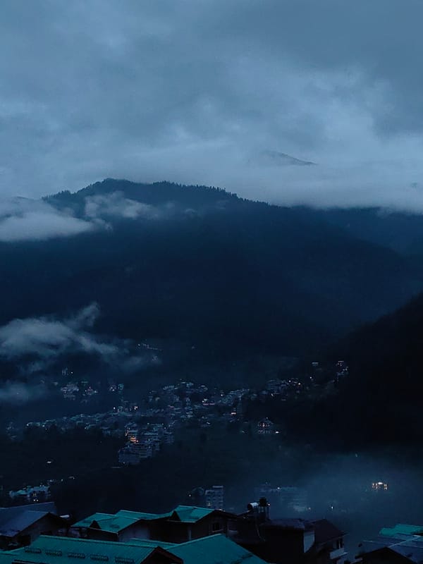 Fog and dusk settle over Vashisht's misty mountain valley