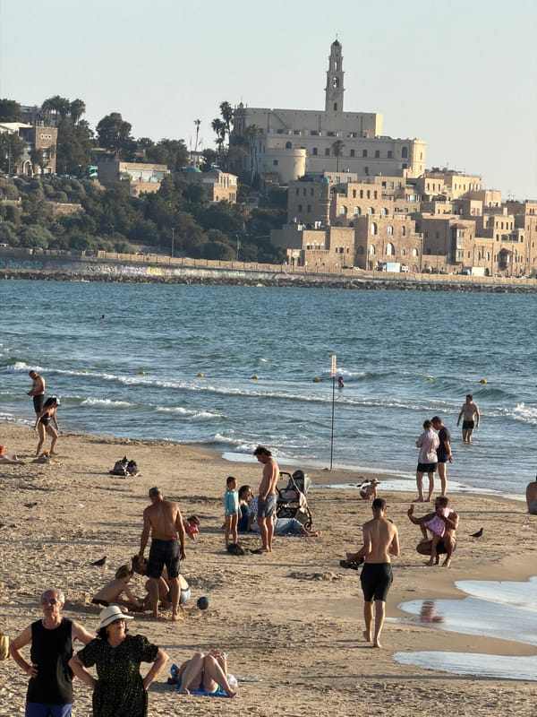 Friends photograph each other near Jaffa coast in Tel Aviv