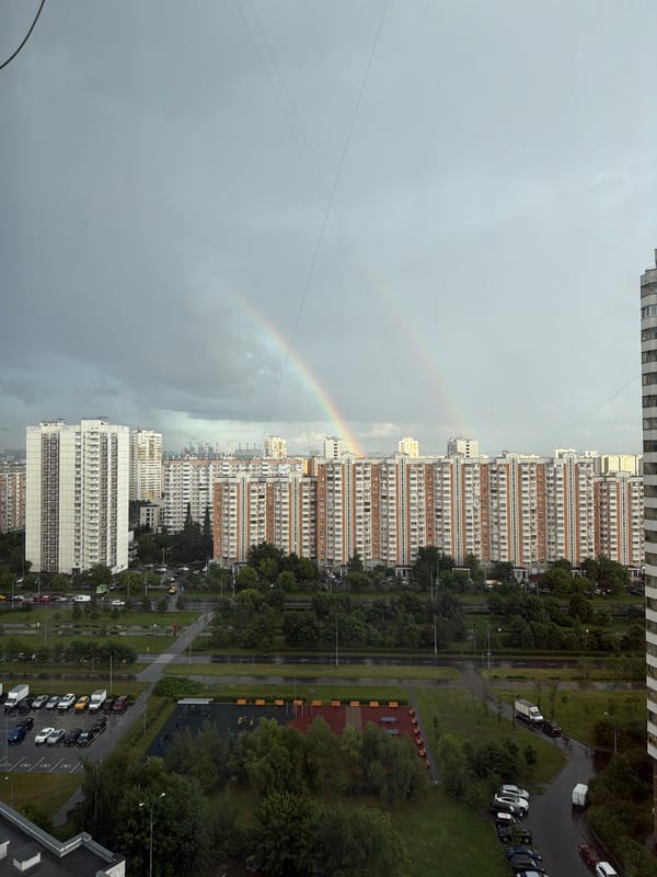 Double rainbow over Moscow apartment blocks, overcast afternoon