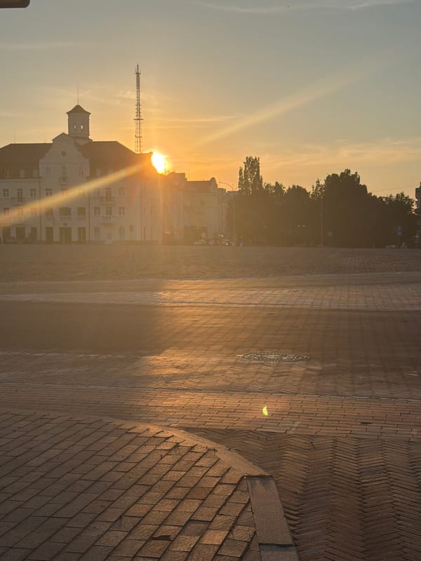 City skyline at golden hour, radio tower and sun-lit building