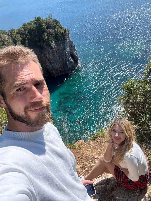 Tourists capture cliff selfie as boat passes below Budva