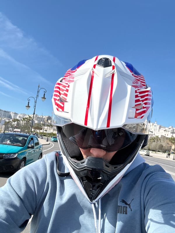 Motorcycle rider cruises Tangier streets in flag-themed helmet