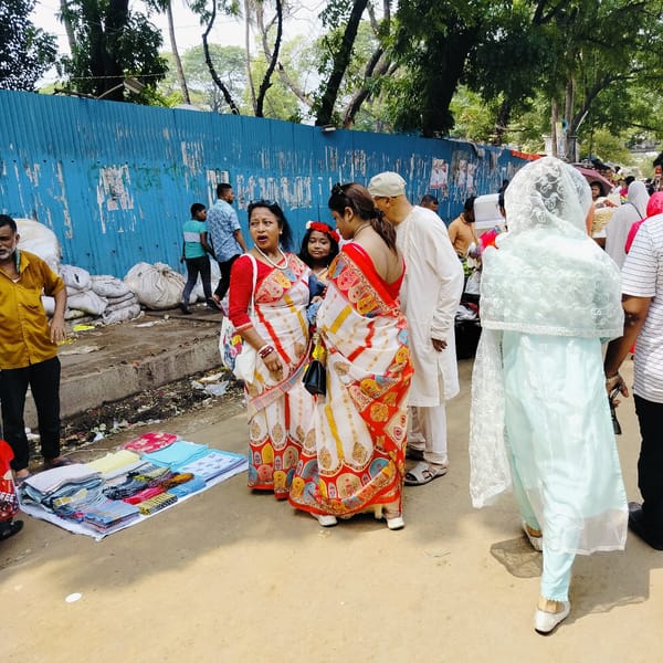 Street vendors conduct business on Dhaka road amid pedestrian traffic