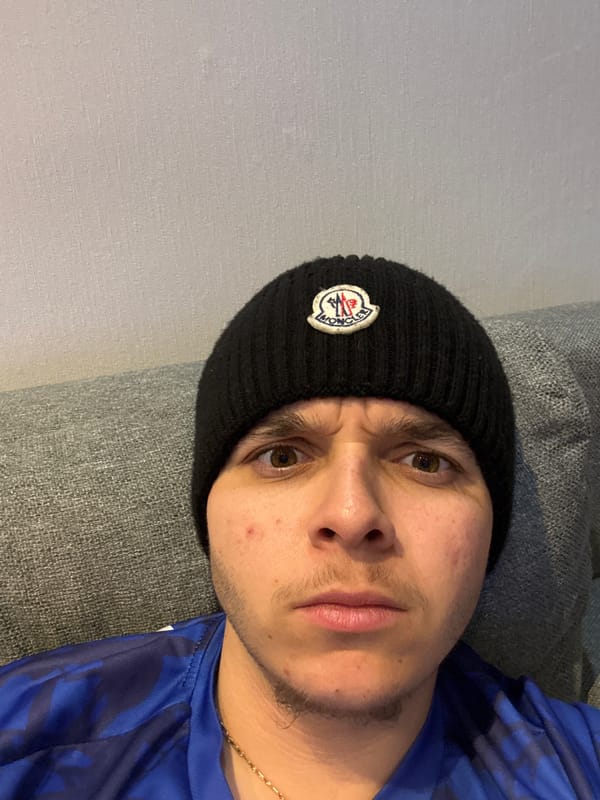 Man in designer beanie rests on couch in Bulgaria