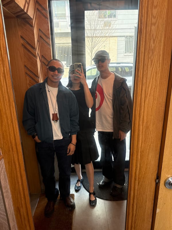 Three people reflected in NYC storefront window