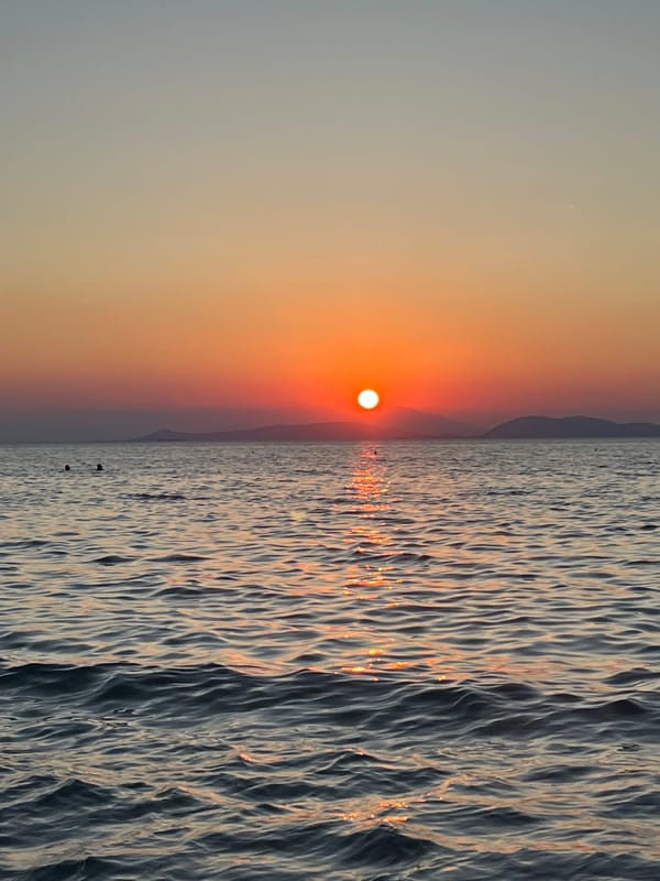 Sunset hour at a packed Vouliagmeni beach, Aegean coast