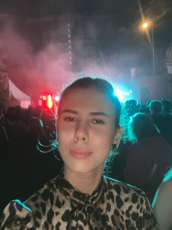 Nighttime outdoor concert with crowd and colorful stage lighting
