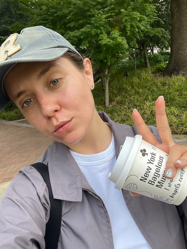 Coffee drinker poses in Shanghai park with NYC-branded cup