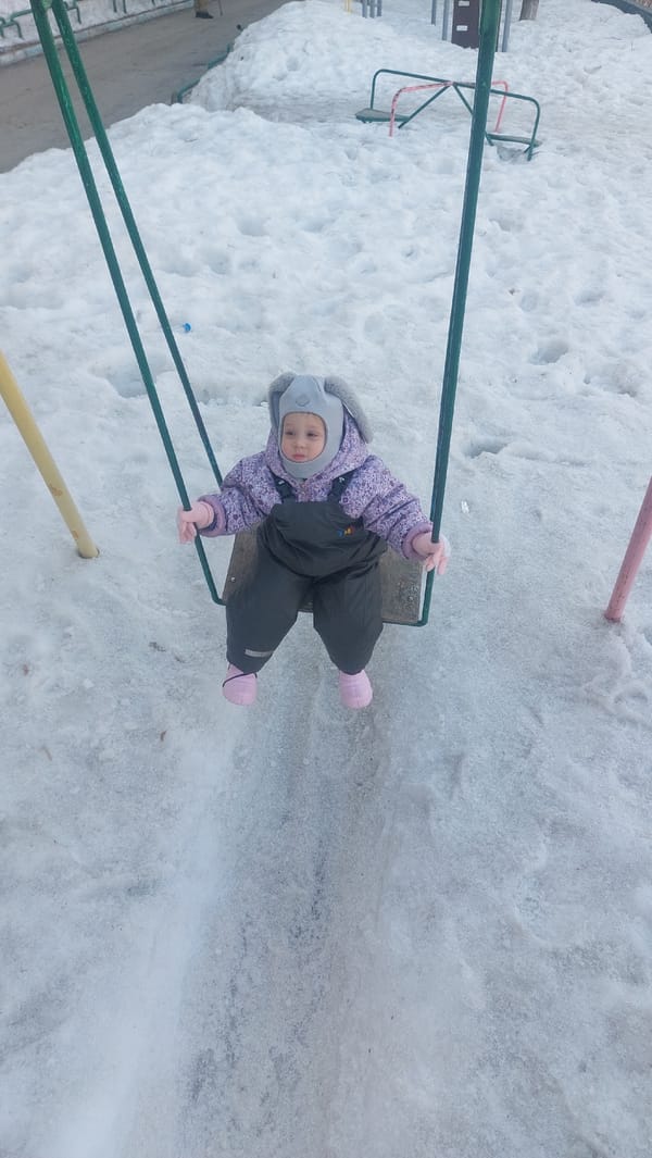 Child plays outdoors in snowy puddles in Novosibirsk